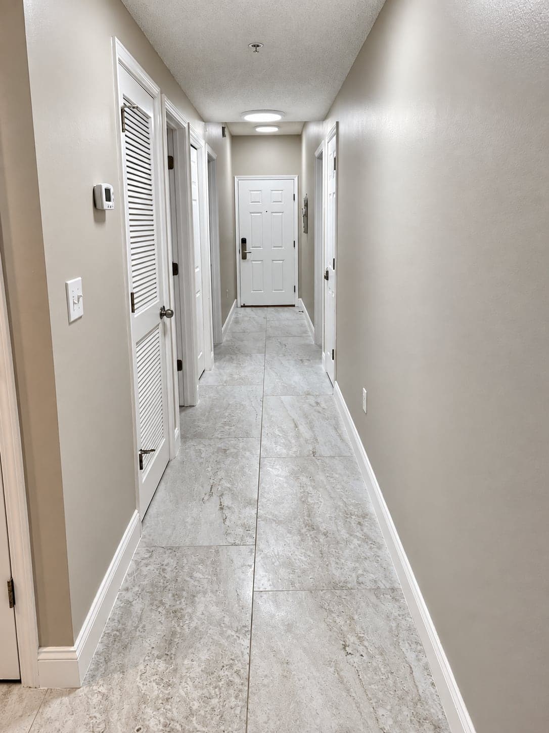 Condo hallway with new porcelain floor tile and fresh paint