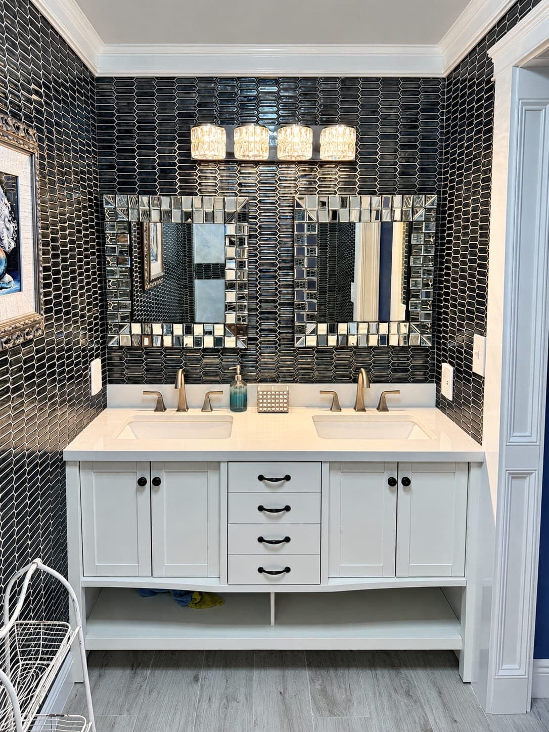 Double vanity with a black mosaic wall and framed mirrors in a remodeled condo bathroom