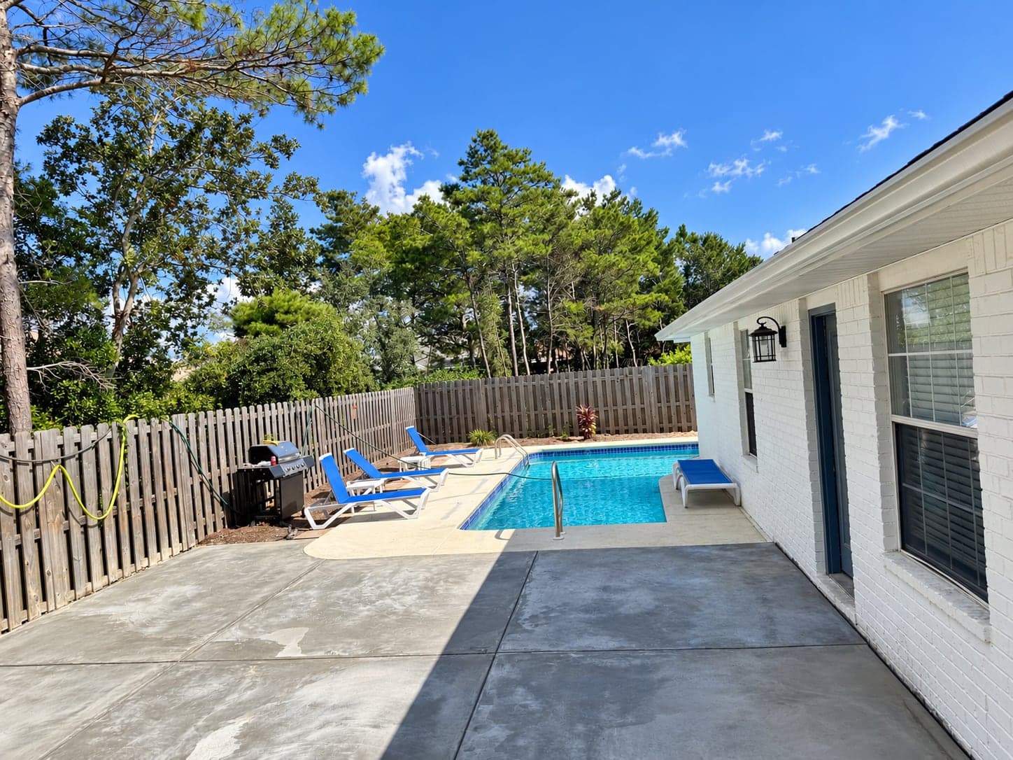 New concrete pool deck poured and finished beside a backyard pool