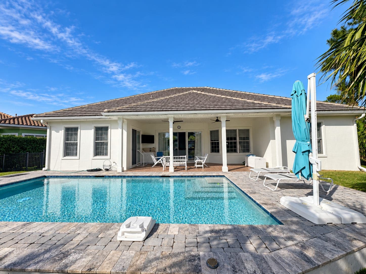 Single-story house with a pool, exterior repainted white