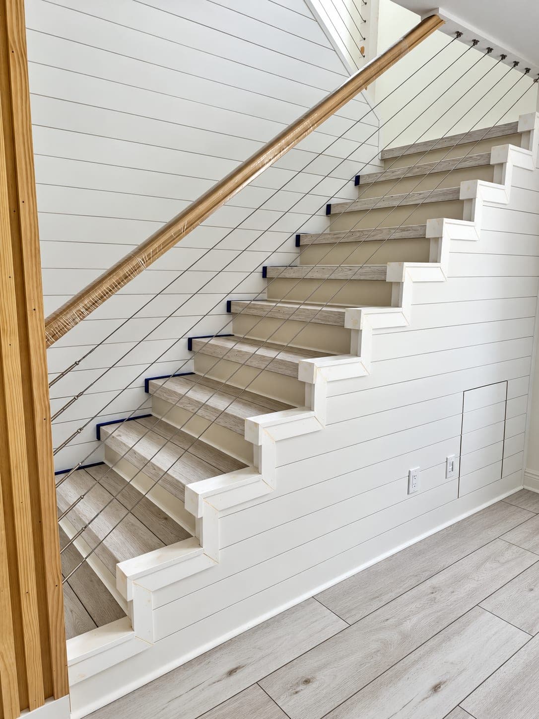 Staircase finished with shiplap and a cable railing