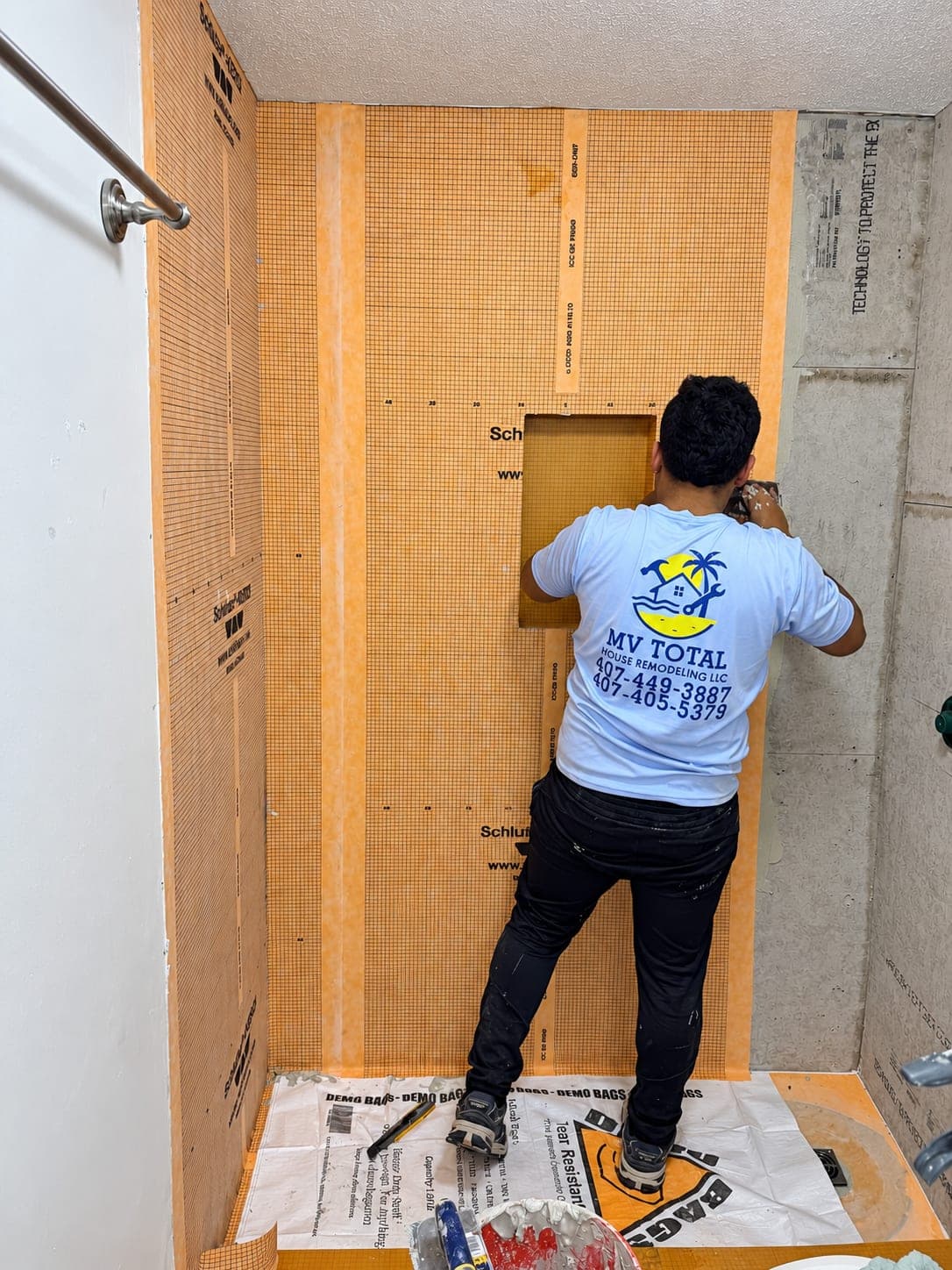 A member of the MV team installing the waterproofing membrane of a shower