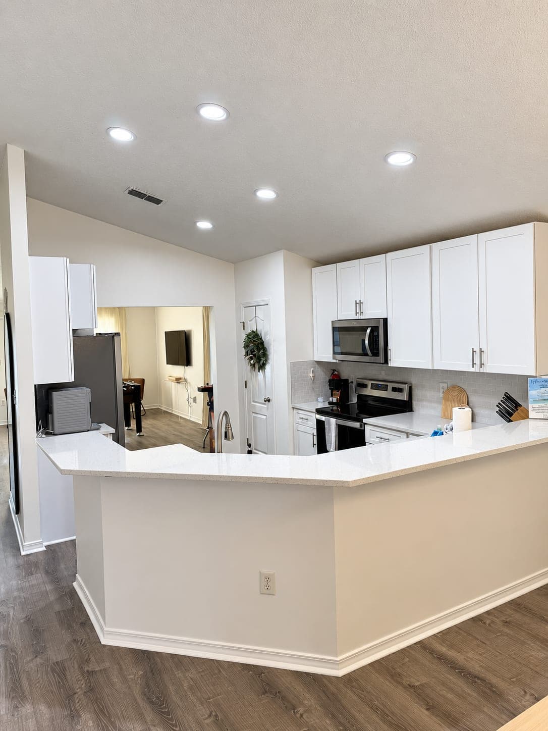 White kitchen with an island and stainless appliances in a remodeled vacation rental
